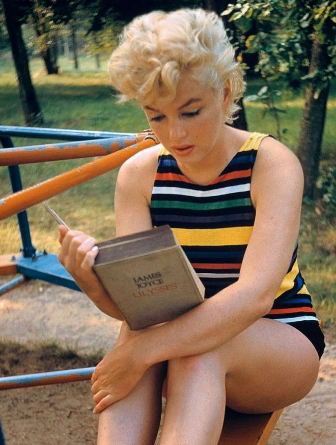 Marilyn legge il libro mentre è seduto sulla giostra dei bambini