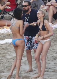Leonardo DiCaprio dikelilingi oleh kanak-kanak perempuan di pantai